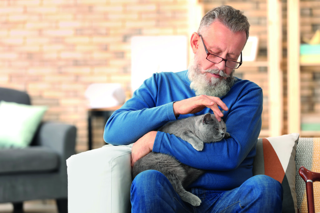 anziano con gatto in braccio